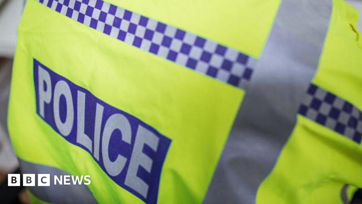 A close-up of a police high-vis jacket. The jacket is bright yellow, with the word "police" in grey, on a blue background.