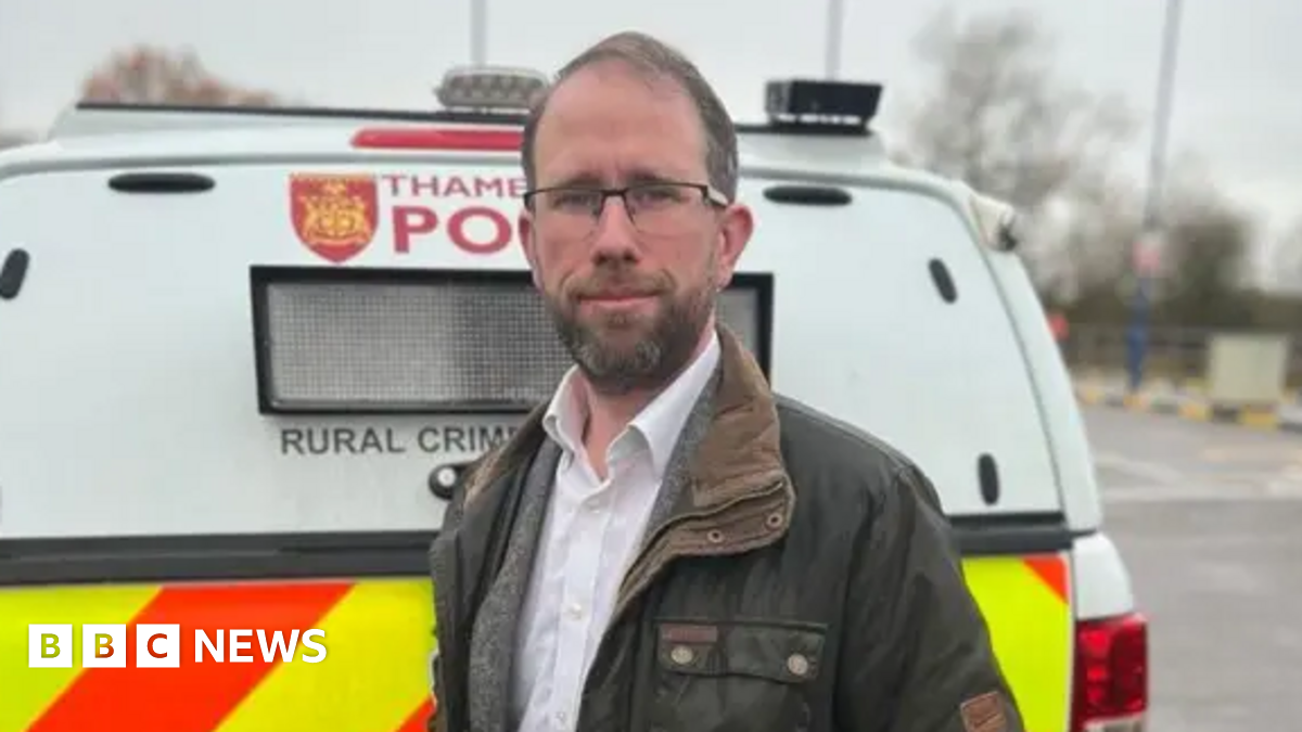 Matthew Barber, dressed in a coat, stood at the back of a Thames Valley Police van.