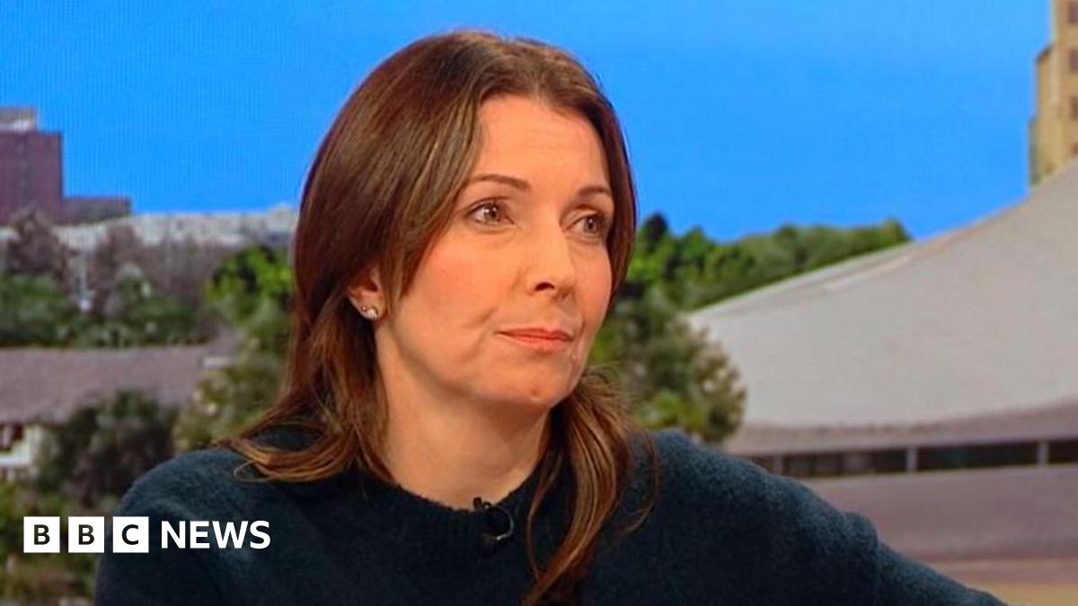Polly sits in the BBC Breakfast studio, she has long brown hair and wears a dark blue jumper
