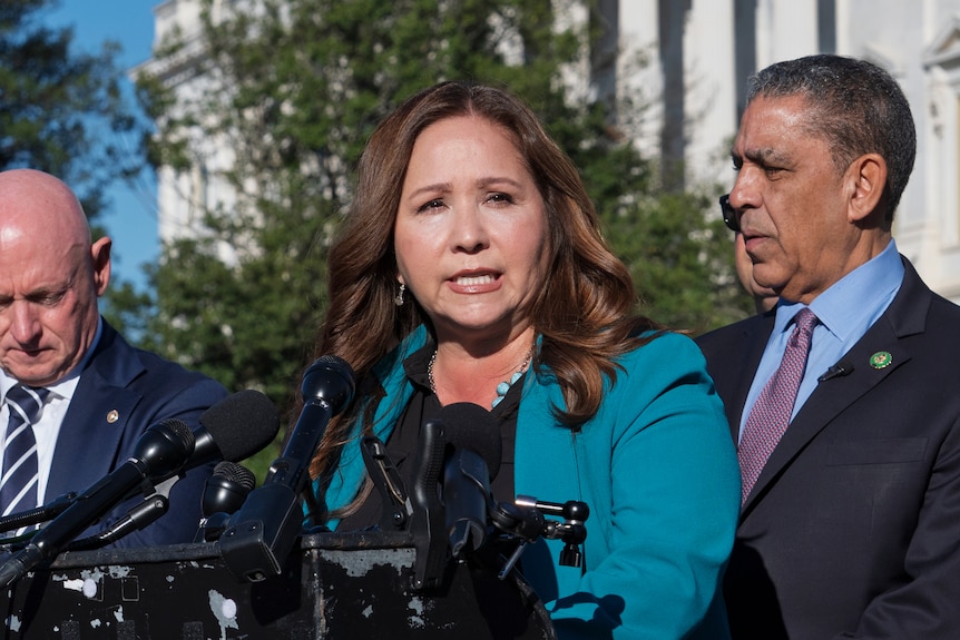 Adelita Grijalva speaking into a microphone in front of the Capitol building.