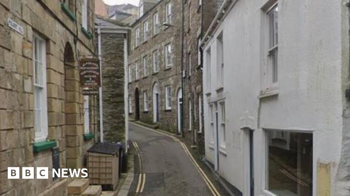 Google Street View image of Polkirt Hill in Mevagissey. It is a narrow single-lane road with double yellow lines on either side. Buildings line the road on both sides.