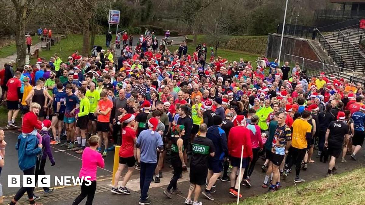 Crowds of runners, many in Santa hats, gather outside.
