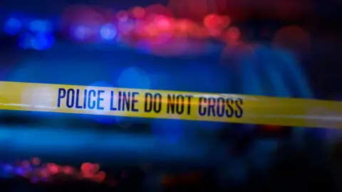 Getty Images Yellow police tape and police car lights
