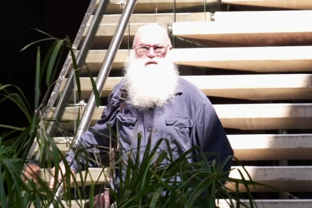 Soren Copley, with a heavy beard standing on courthouse steps.