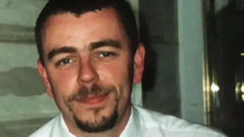 Alison Mark Jenner, pictured by Alison, in a white shirt and tie. 