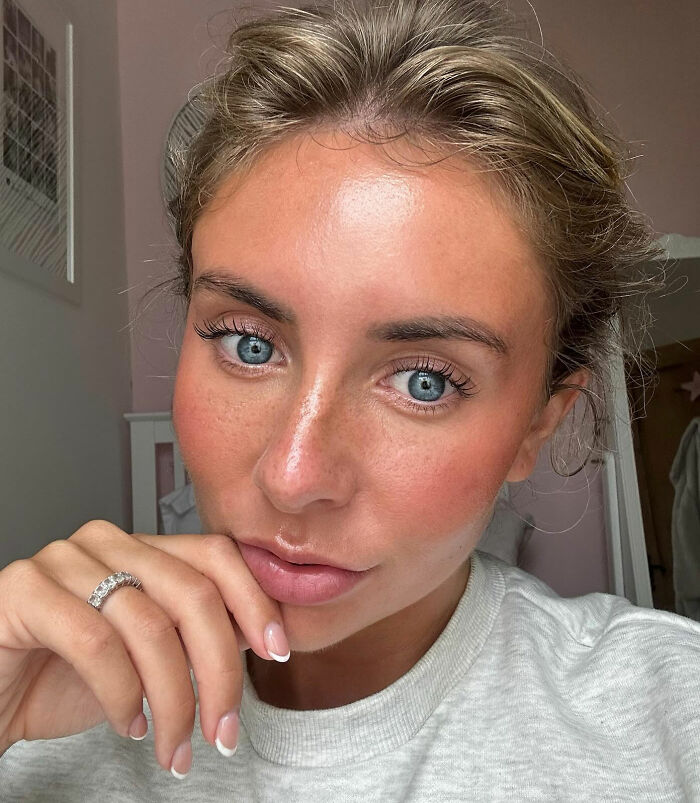 Close-up of Bonnie Blue with blue eyes and natural makeup, contemplating her fate after controversial video arrest.