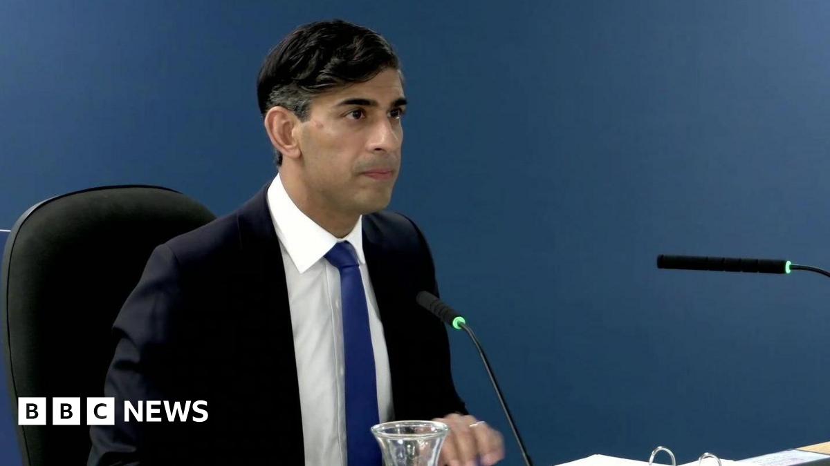 Rishi Sunak sitting down at the Covid inquiry giving evidence. He is wearing a dark-blue suit with a white shirt and royal blue tie.