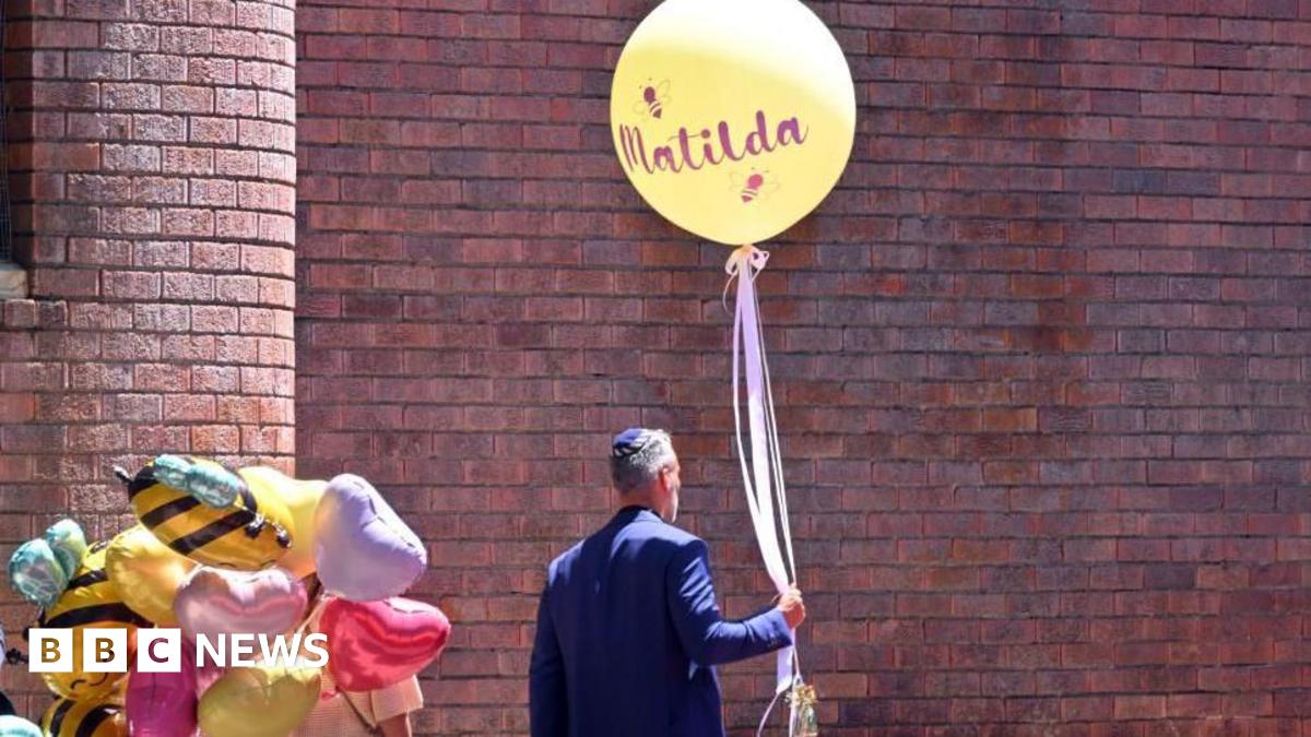 A man holds a balloon reading 'Matilda' during the funeral for 10-year-old Matilda a Bondi Beach shooting victim, at Chevra Kadisha Memorial Hall in Sydney