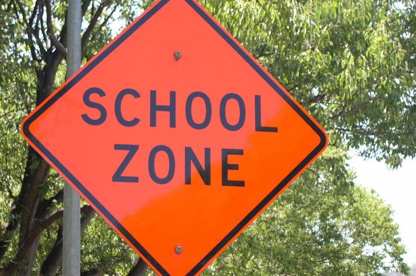 A brightly-coloured sign that says "school zone".