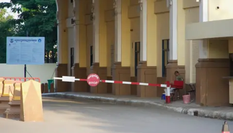 A lonely guard sits at the closed border crossing between Thailand and Cambodia