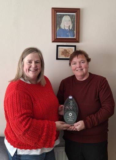 Liz O'Halloran, Mayfield CDP, with Lisa Murphy and her volunteer award, pictured with a portrait of the late Mary Kelly.