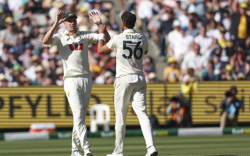 Australia's Mitchell Starc (R) and Cameron Green celebrate the wicket of England's Ben Stokes.