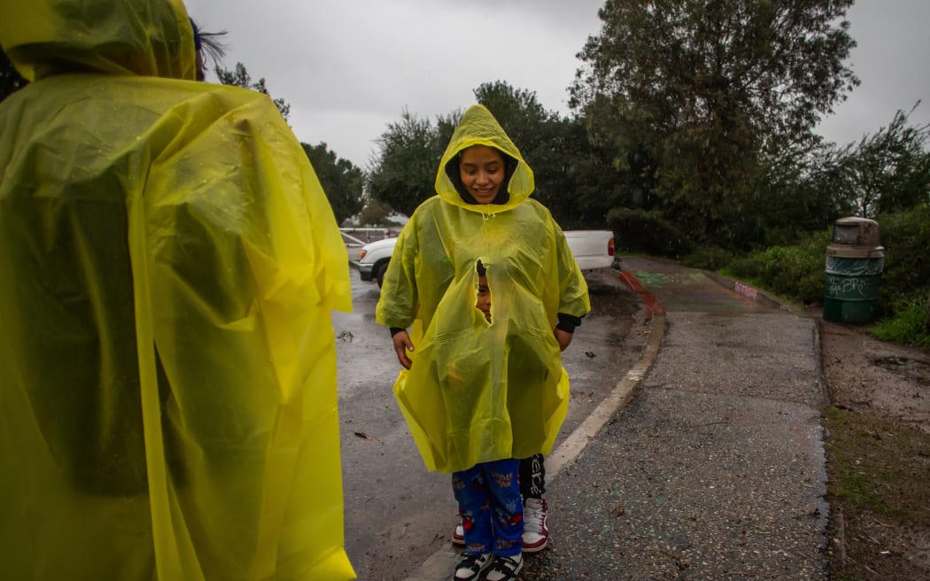 A family walks at Elysian Park in the rain on December 24, 2025 in Los Angeles, California. A major winter storm rolled into California on December 23, forcing hundreds of evacuations in burn areas while threatening flooding and travel delays through Christmas for much of the state, officials said.
A 