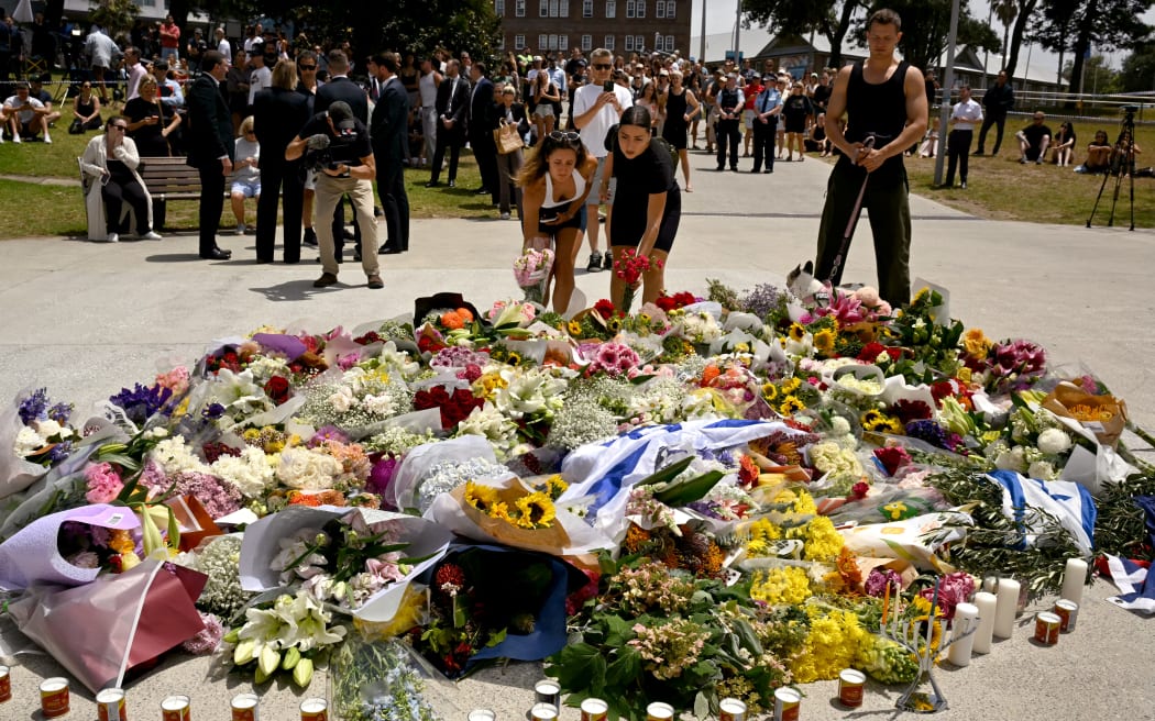 Members of the local community lay flowers at the Bondi Pavillion in memory of the victims of a shooting at Bondi Beach, in Sydney on December 15, 2025. A father-and-son team toting long-barrelled guns shot and killed 15 people including a 10-year-old girl at Sydney's Bondi Beach on December 14, with authorities labelling it an antisemitic terrorist attack on a Jewish festival. (Photo by Saeed KHAN / AFP)