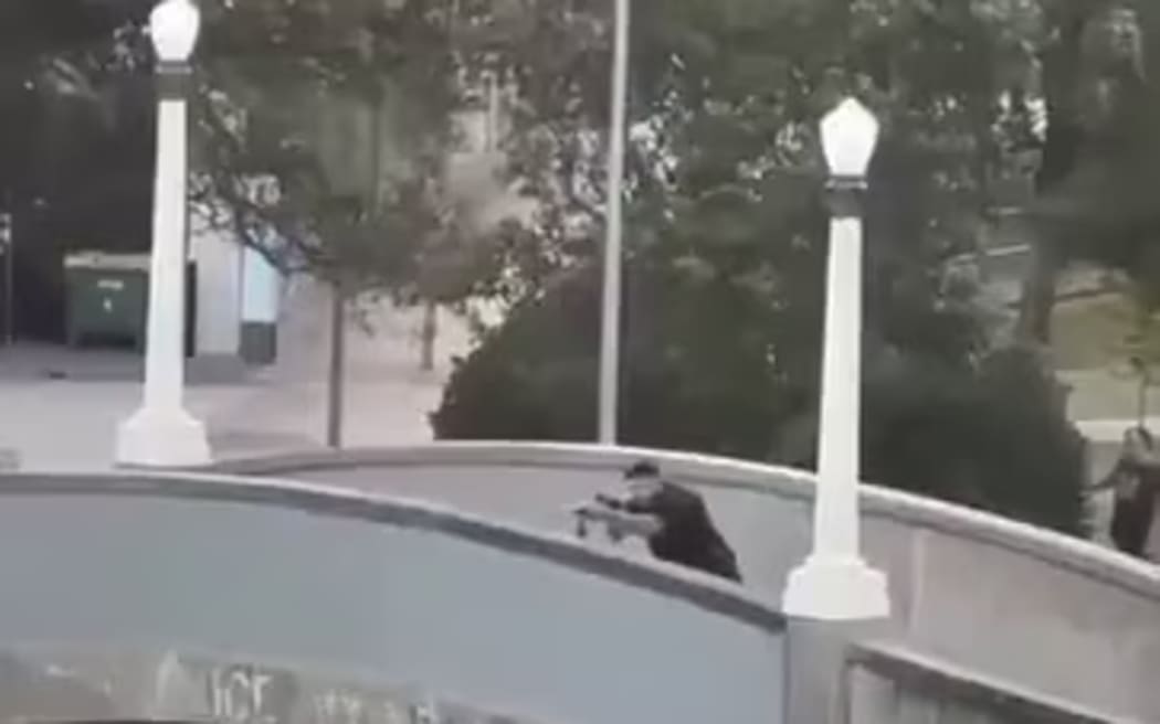 One of the Bondi shooters fires from a bridge.