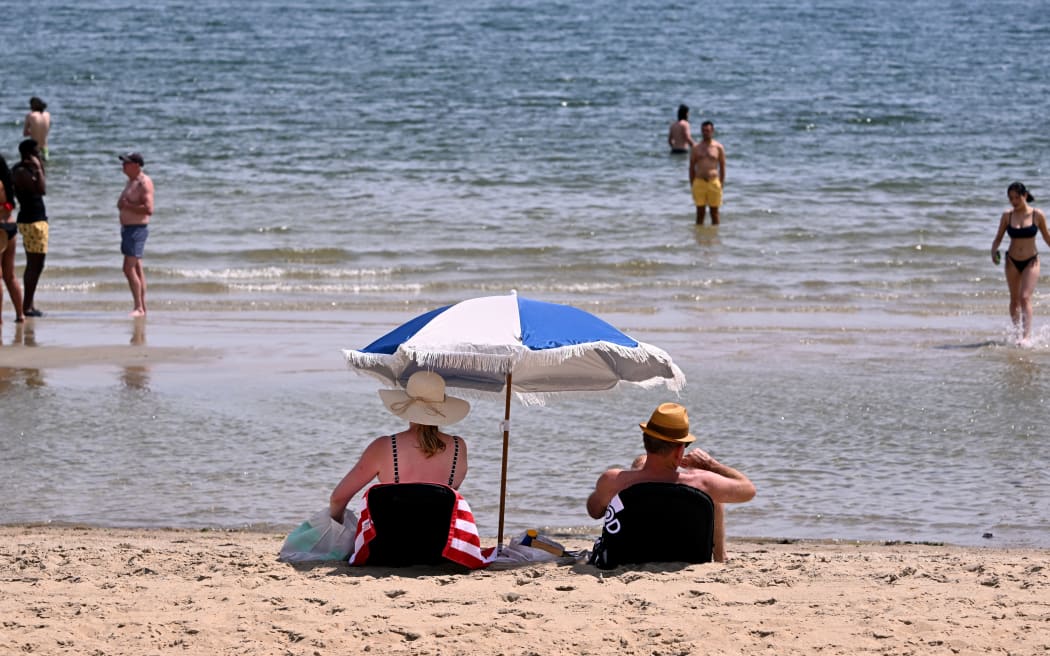 People cool off in heatwave conditions at Melbourne's St Kilda Beach on November 22, 2024. (Photo by William WEST / AFP)