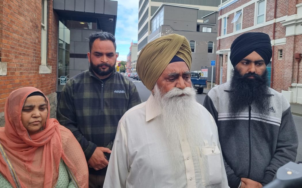 Nishan Singh, in white, who is the father of murder victim Gurjit Singh, is pictured outside court in Dunedin.