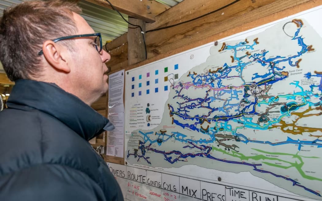 Richard Harris looking over a 2018 map of Tank Cave, an expansive cave system on the Limestone Coast, SA.