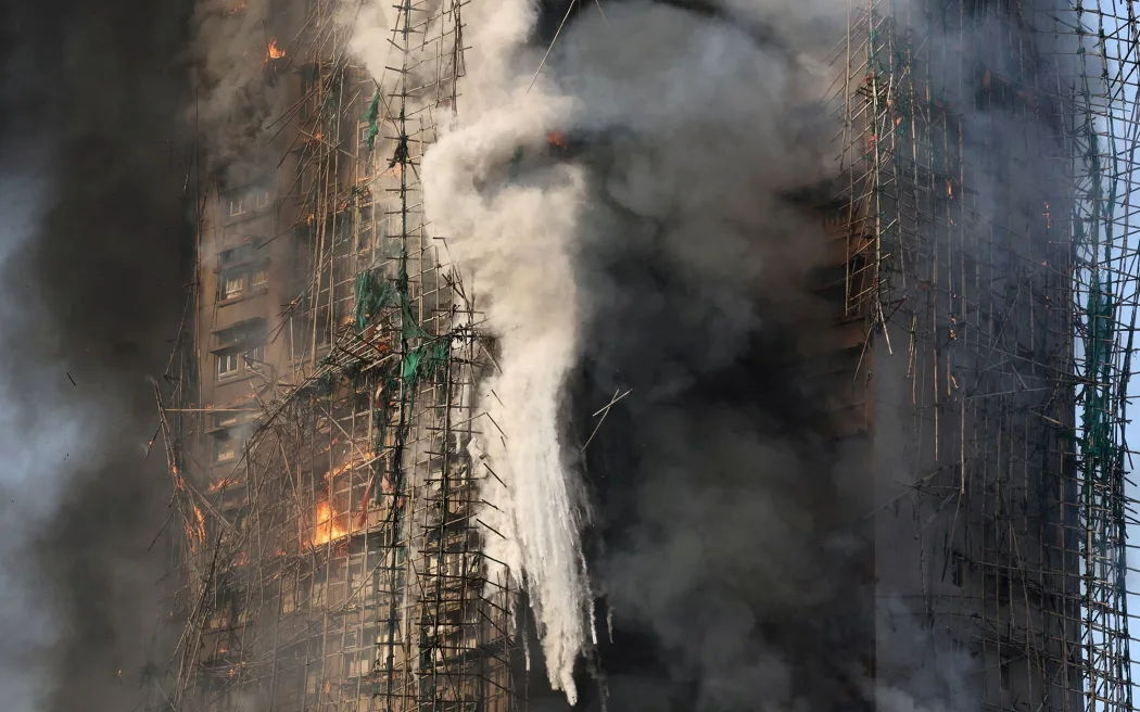 Flames engulf bamboo scaffolding across multiple buildings on November 26, 2025.