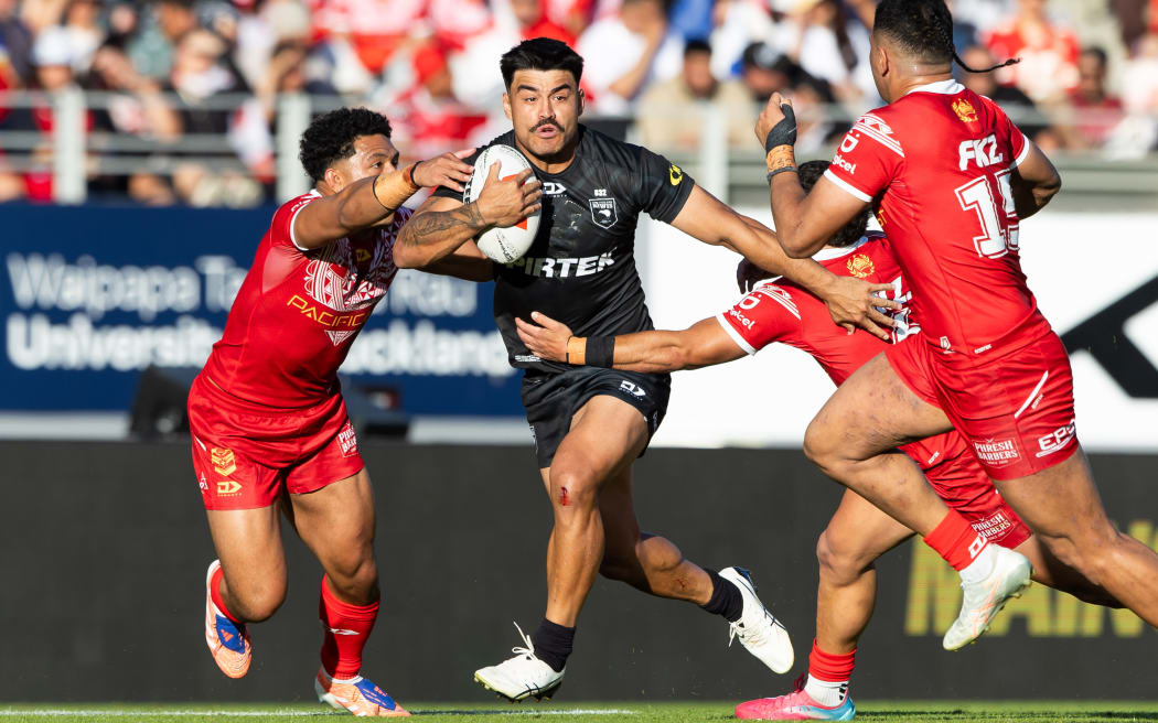 Eliesa Katoa (r) comes across on defence as Kiwis centre Matthew Timoko makes a break.