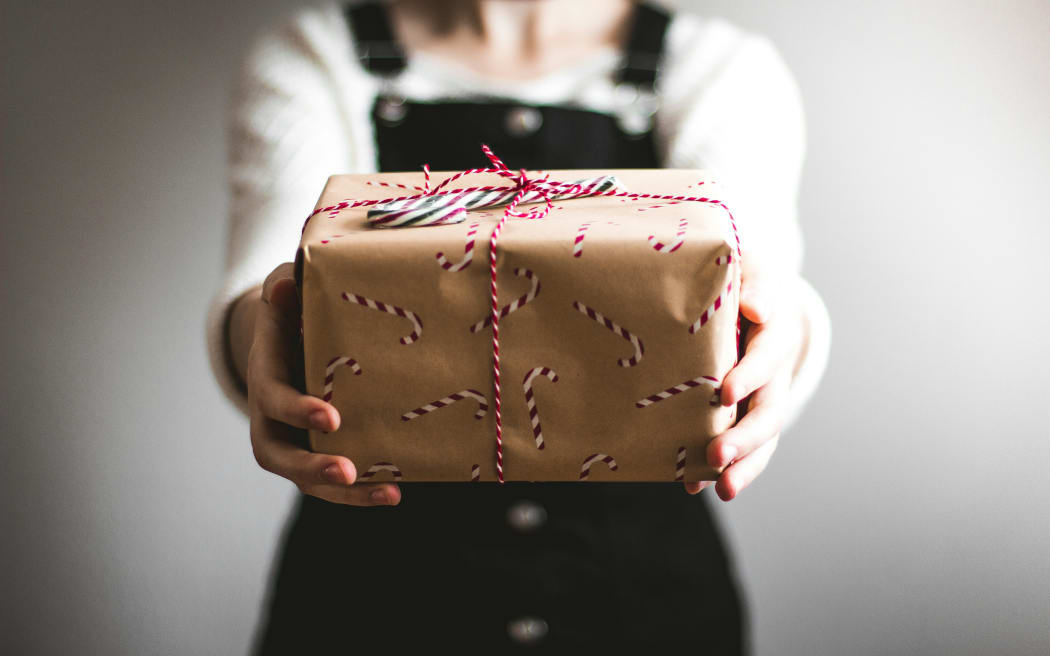 A person holding a wrapped Christmas present.