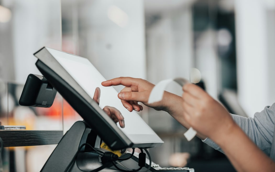 A retailer checking out a sale at the counter.
