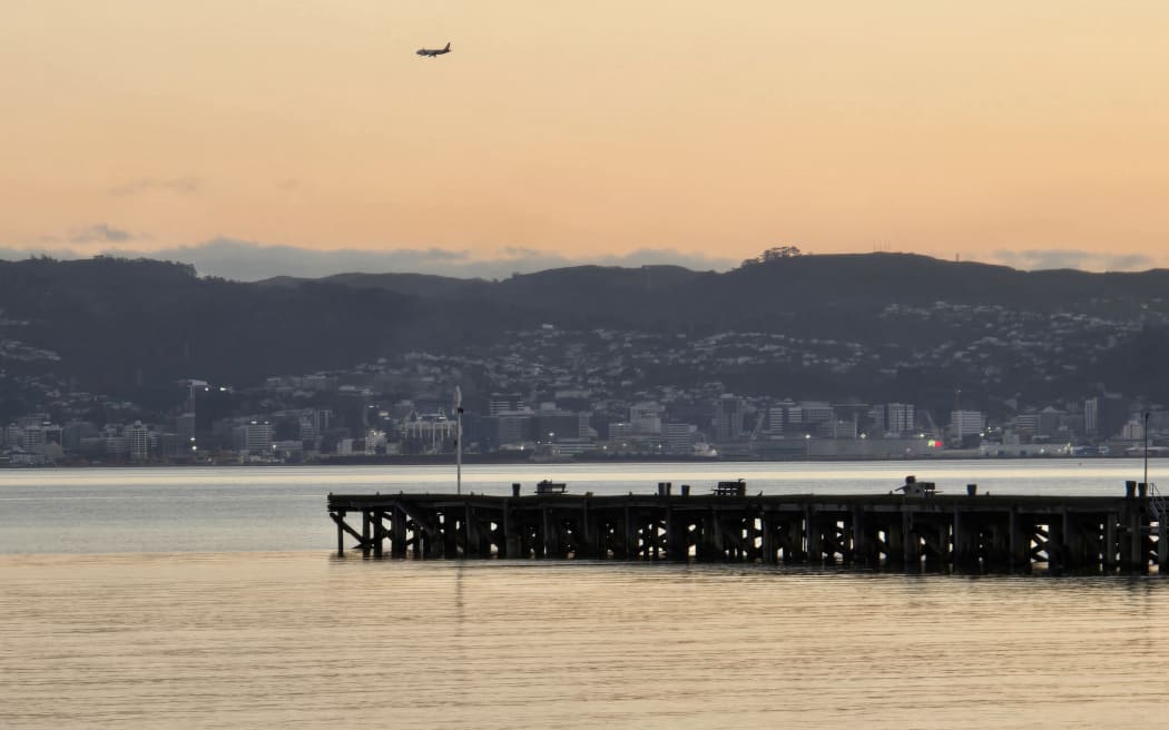 Petone Wharf at sunset, in July 2024, looking across the harbour at Wellington waterfront.