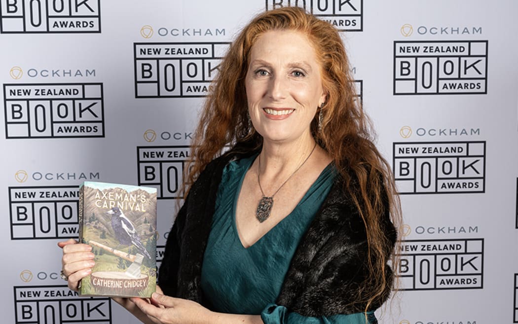 Catherine Chidgey holds a copy of her Ockham New Zealand Book Award-winning novel, The Axeman's Carnival.