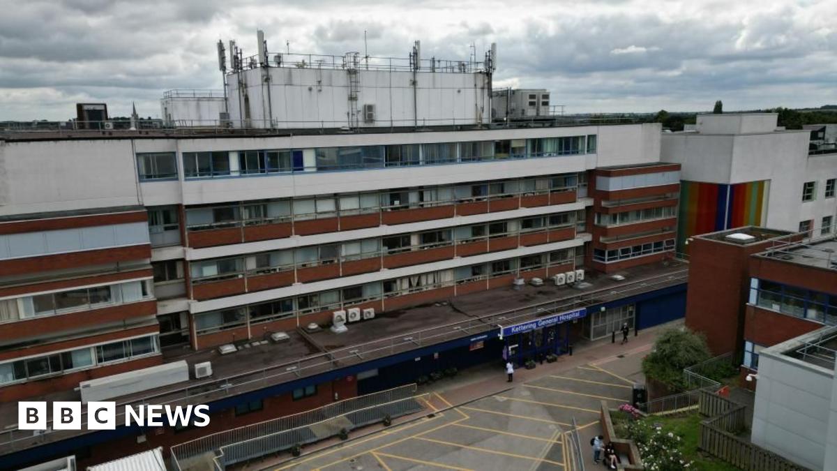 The outside of a five-storey hospital building with white and brown panelling.