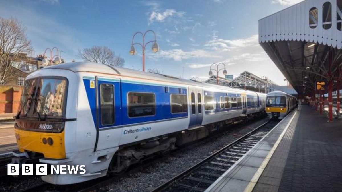 Two Chiltern Railways trains at a station platform in red, yellow and white livery.