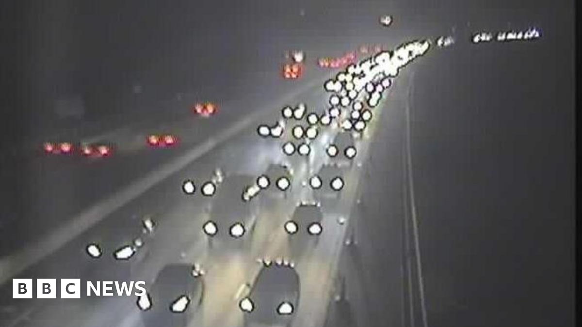 Cars are moving slowly on a motorway eastbound carriageway after a crash, with vehicles in all lanes seen for a while.
