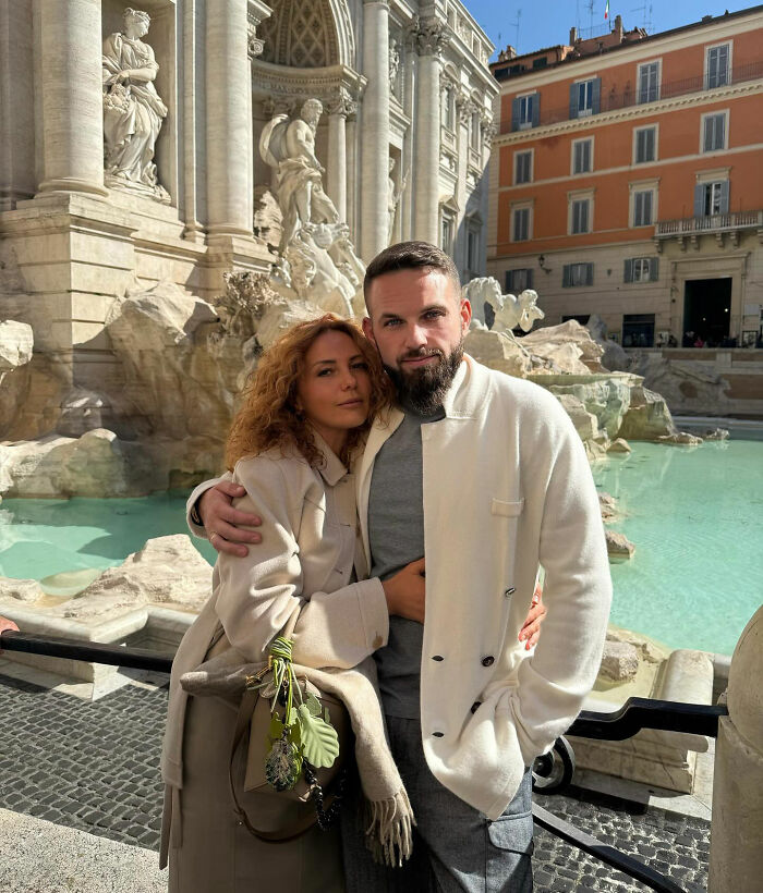 Couple posing by historic fountain, representing tragic story of crypto scammer found dismembered in Dubai mall case.