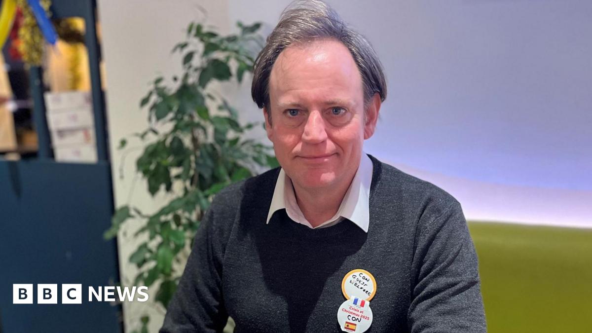 A food serving counter apparently in a hotel or catering facility and a queue of people, men and a woman, seen from behind.