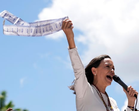 Opposition leader Maria Corina Machado displays vote tally sheets during a protest against the reelection of President Nicolas Maduro one month after the disputed 2024 presidential vote which she says the opposition won by a landslide.