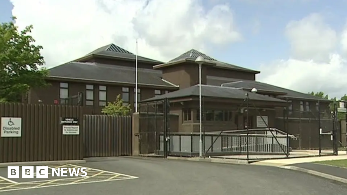 A brown building with metal gates outside.