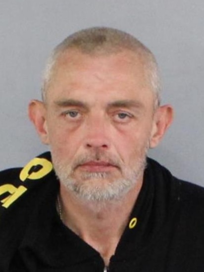 A mugshot of John Argento, a 47-year-old man with grey hair and a fair complexion.