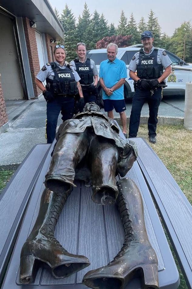 Royal Canadian Mounted Police officers stand next the damaged Amelia Earhart statue on August 11, after it was found abandoned off a rural roadway.