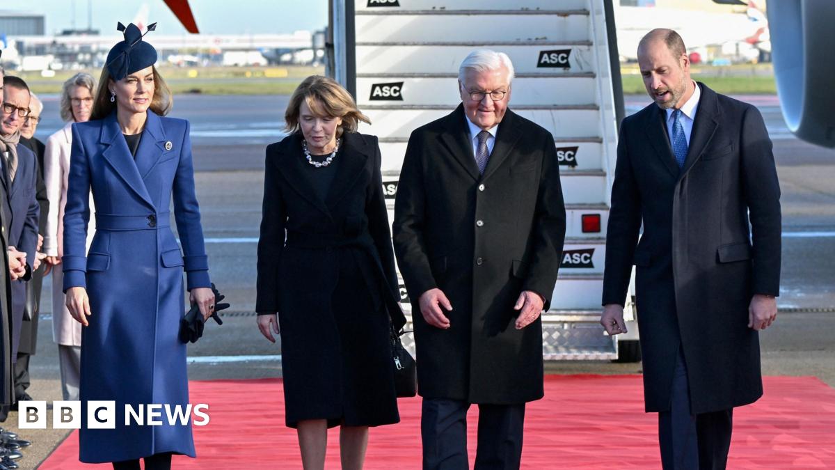 Four people walk on red carpet in front of a plane with Catherine wearing a blue jacket, and Elke Budenbender wearing a black dress, Frank-Walter Steinmeier wearing a black suit jacket and William wearing a black suit jacket