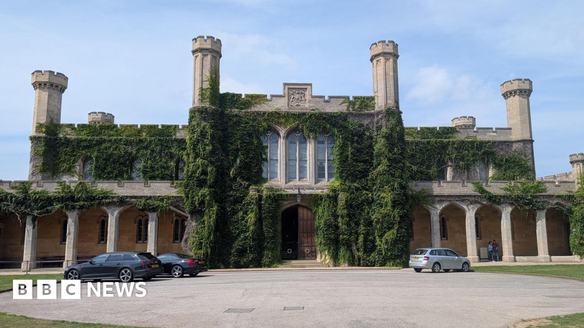 An exterior shot of Lincoln Crown Court. Three cars are parked in front. The sky is blue.