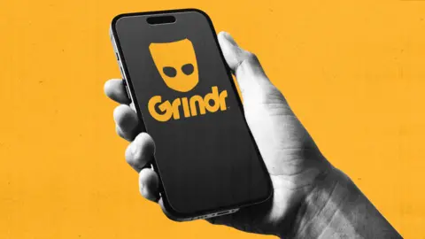 BBC A hand holds a mobile phone with Grindr logo on it. Background is bright yellow. 