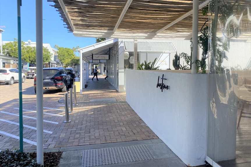 A pathway runs alongside a white wall with Destino written on it