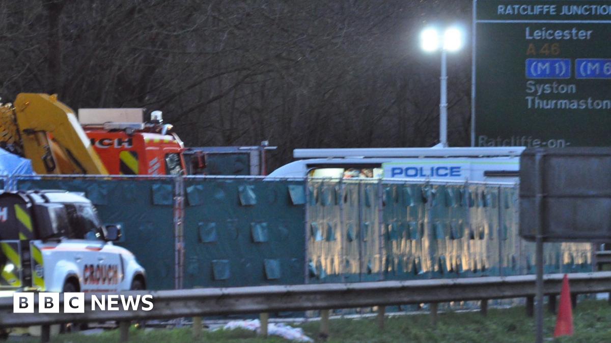 A fence with dark green screens is in place at the scene, as well as two recovery vehicles and a police van