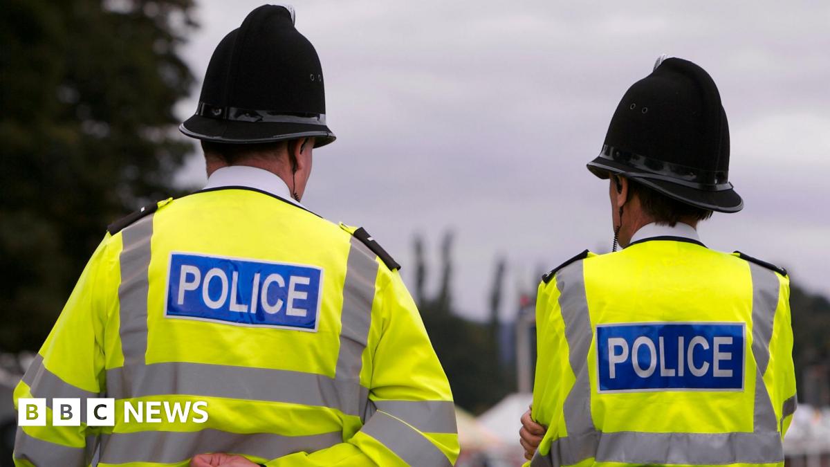 Two police officers in hi-vis police jackets and black helmets