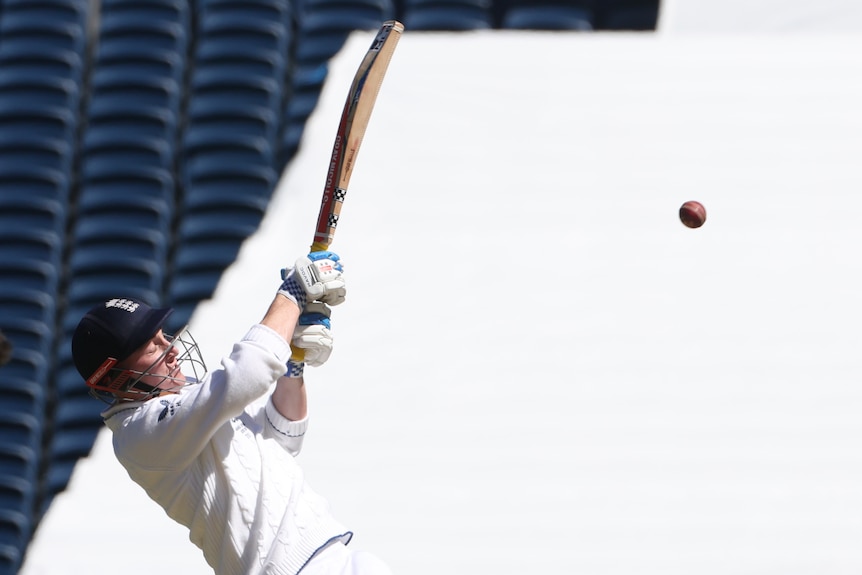 A cricket ball flies away from Harry Brook as he plays a cricket shot.