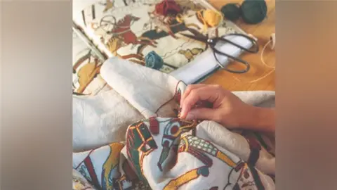 Search Press/Mark Davison Mia's hands sewing detail on her replica of the Bayeux Tapestry.
