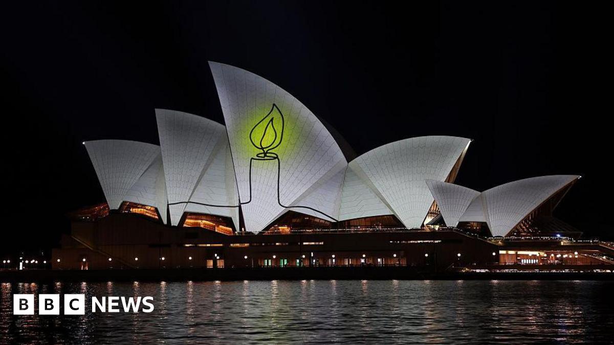 The image of a candle lit up on the Opera House sails