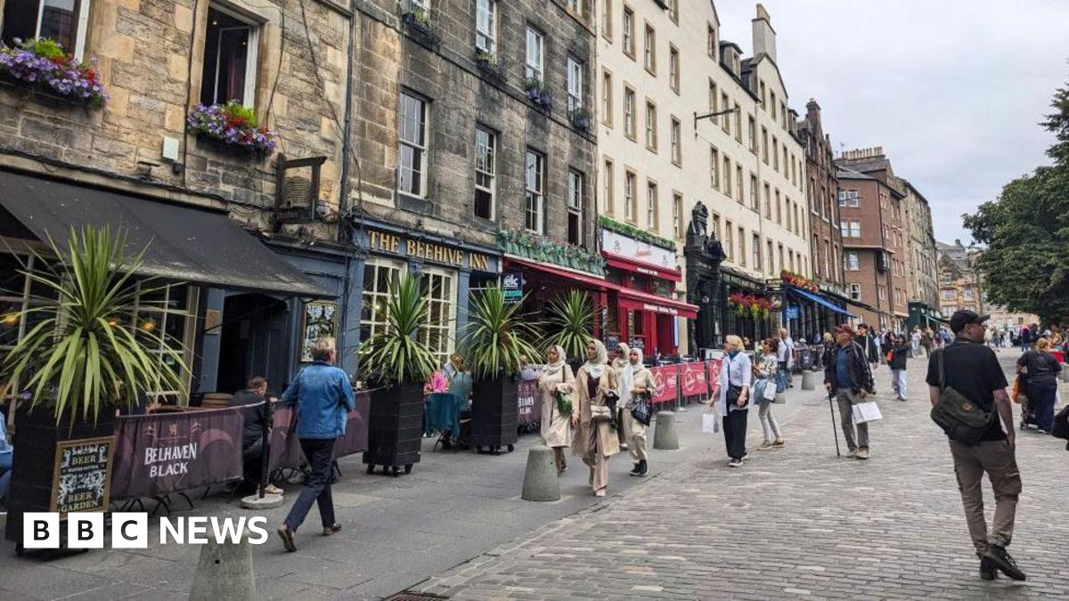 A cobbled and pedestrianised street with pubs and restaurants on one side.