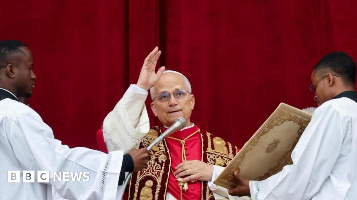 The Pope waves to worshippers from the popemobile