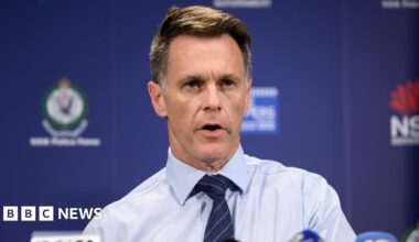 Close-up of Chris Minns wearing a blue shirt and tie at a press conference