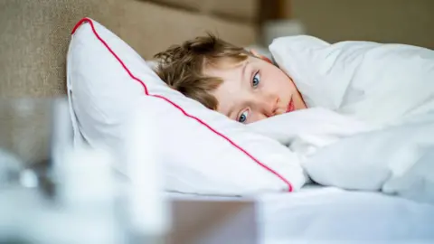 Getty Images A stock photo of a child sick in bed